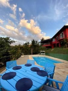 彼得罗波利斯Casa em Secretário (@chacaradosolsecretario)的游泳池旁的蓝色桌椅