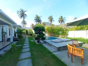 马塔兰torok ocean homestay的后院设有游泳池、长凳和棕榈树