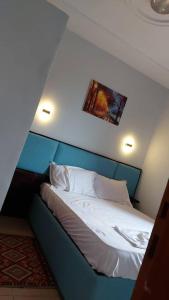 NkongsambaLa Cité des Anges的一间卧室配有一张蓝色床头板的床