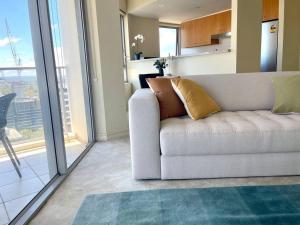 悉尼North Sydney 2 Bedroom - Pool Parking Gym Spa Sleeps 6的带沙发和大窗户的客厅