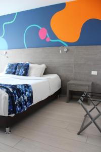 波哥大Agora Suites Self-Service Boutique Hotel的一间卧室配有一张带彩色墙壁的床