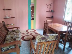 罗索Ian Creole Garaden Cottages的一间带桌椅的用餐室