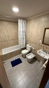 乌斯怀亚Casa Los Ñires Ushuaia的浴室配有2个盥洗盆、卫生间和浴缸。