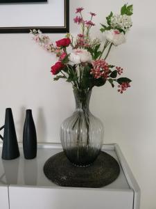 巴拿马城Beautiful Apartment 2 BR的花瓶,花朵放在桌子上