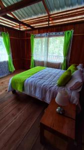 San CiprianoMama Yeya raíces的一间卧室配有一张带绿色床单的床和一张桌子