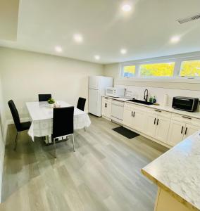 多伦多VJ Home的一间带桌椅的厨房和一间带白色橱柜的厨房
