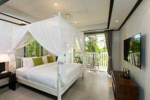 卡塔海滩Katamanda Villa Mila A1的一间卧室配有一张带天蓬的白色床