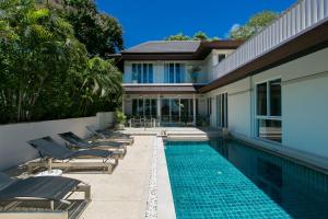 卡塔海滩Katamanda Villa Mila A1的一座房子旁带躺椅的游泳池
