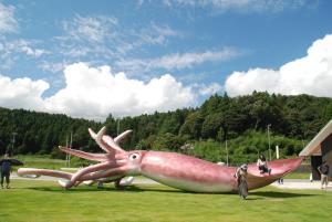 金泽城镇41胶囊旅馆的 ⁇ 鱼雕像,坐在草上
