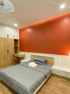 胡志明市Happy Hotel Bình Tân的一间卧室配有一张橙色墙壁的床
