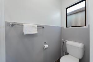 陶波Central Inn Taupo的一间带白色卫生间的浴室和窗户。