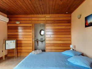 圣菲利普Ferme auberge le Ti'planteur的一间卧室设有蓝色的床和木墙