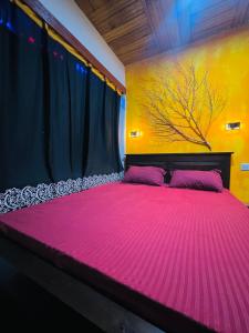 RambukkanaGrand Cabin Pinnawala的一间卧室配有一张大粉色床和树床头板