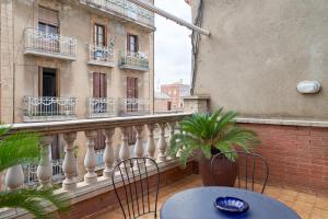 巴塞罗那Stay U-nique House Torre Damians的一个带桌椅的阳台和一座建筑