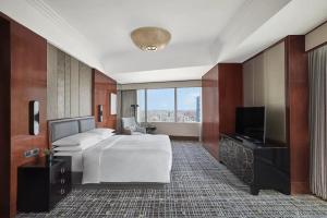 上海上海雅居乐万豪侯爵酒店的酒店客房,配有床和电视