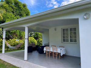 勒拉芒坦Casa Tropical · T3 Calme & Spacieux的一个带桌椅的有盖庭院