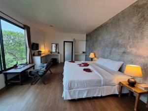麦岛Seabreeze @ Koh Mak的卧室配有一张白色大床、一张书桌和窗户。