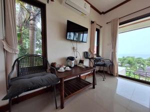 麦岛Seabreeze @ Koh Mak的客房设有桌子、椅子和窗户。