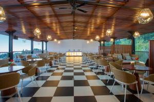 特里特斯Surya Hotel & Cottages Prigen的餐厅设有格子地板和桌椅