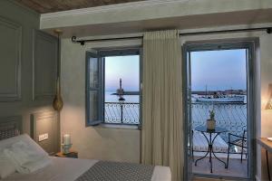 干尼亚Elia Zampeliou Hotel的一间卧室设有一张床,享有阳台的景色