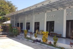 KebumenOYO 93025 Surya Abadi Homestay Syariah的一座带长椅和桌子的庭院的建筑