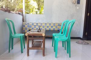 KebumenOYO 93025 Surya Abadi Homestay Syariah的一张桌子和两把椅子以及一张桌子和一张长凳
