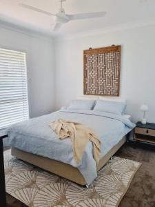 罗布Surfmist House的一间卧室配有一张床铺,床上有毯子