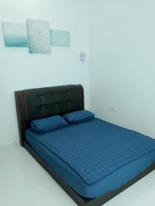 瓜拉丁加奴Homestay Villa Muslim Kuala Terengganu with pool and parking的一张床上有蓝色枕头的睡床