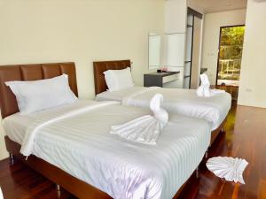皮皮岛Phi Phi Mountain Beach Resort SHA Certified的客房内的两张床和白色毛巾