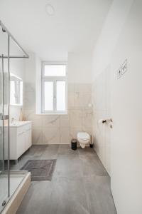 维也纳Chic Central City Rooms by Home2的白色的浴室设有卫生间和水槽。