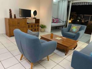 普纳奥亚Moehani Beach Lodge的客厅配有蓝色椅子和茶几