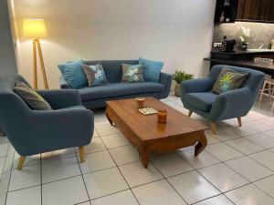 普纳奥亚Moehani Beach Lodge的客厅配有2张蓝色沙发和1张咖啡桌