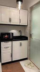 利雅德Modern studio with self check-in的厨房配有白色橱柜和白色冰箱。