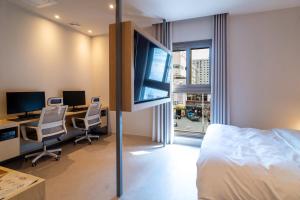 高阳市Goyang Hotel Yuji的酒店客房设有一张床、书桌和电视。