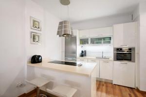 圭马尔港Apartamento Playa的白色的厨房配有白色橱柜和水槽