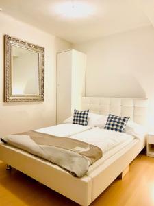 玛利亚采尔Mariazeller Resort Landliebe的卧室配有一张带镜子的白色大床