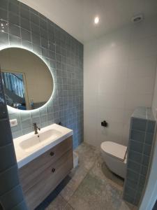 奥门Vakantiewoning - Veurom的一间带水槽、卫生间和镜子的浴室