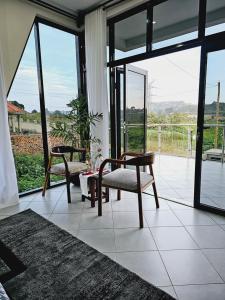 坎帕拉Muguet by Ibiscot development的客厅配有两把椅子和大窗户