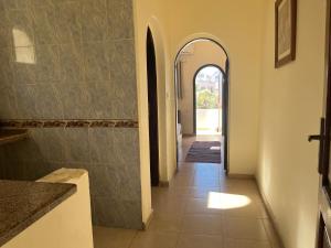 达哈布Malaz Motel的走廊设有拱门,铺有瓷砖地板