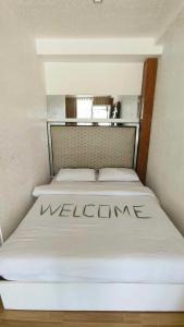 博洛德Amanzara Bohol Resort的小房间的一个床位,上面有迎宾标志