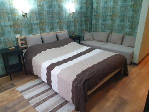 布什泰尼Poiana Golf Chalet的一间卧室配有一张大床和一张沙发