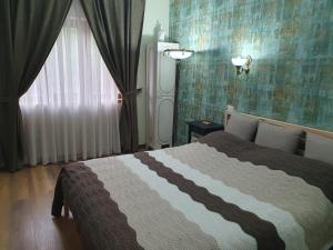 布什泰尼Poiana Golf Chalet的一间卧室设有一张床和一个窗口