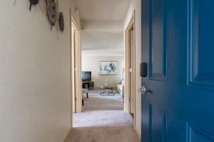 西雅图Beautiful and cozy one bedroom apartment -WiFi, BBQ, Patio, Dog park, close to Greenlake and Northgate的走廊设有蓝色门和客厅
