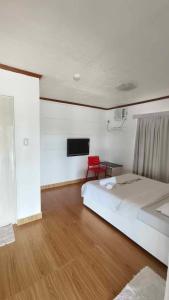 博洛德Amanzara Bohol Resort的一间卧室配有一张床和一张红色椅子