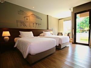 清刊River Tree Resort的一间卧室设有两张床,墙上挂着一幅画