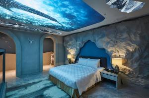 台中市木木行馆的一间卧室配有一张蓝色天花板的床
