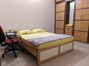 迈索尔Athreyas@60/A的一间卧室配有一张床和一把椅子