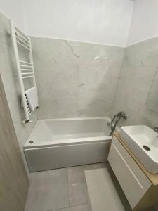 RoşuApartament tip studio的白色的浴室设有浴缸和水槽。