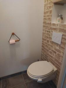 PoupryPetite maison au calme的浴室设有白色卫生间和砖墙