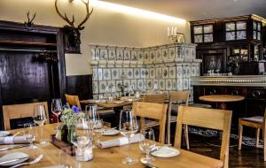 KirchhofenKrone - das Gasthaus的餐厅设有木桌、椅子和壁炉